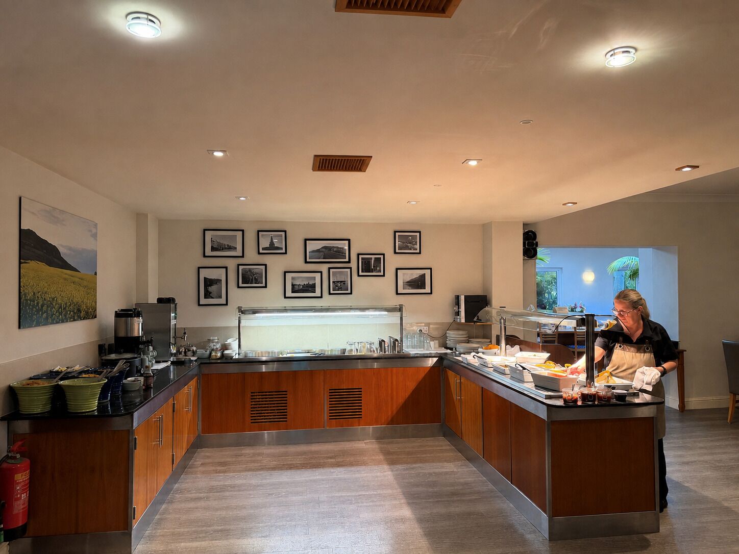 A modern kitchen with a central island, equipped with a coffee machine, a refrigerator, and various food items.