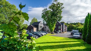 A residential area with multiple houses, a parking lot, and a tree in the foreground. - Wilton Hotel Bray (Bray)