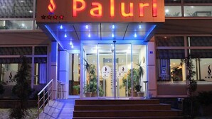 A hotel entrance with a sign reading "Paluri" and a flame logo. - Paluri Hotel (Hopa)
