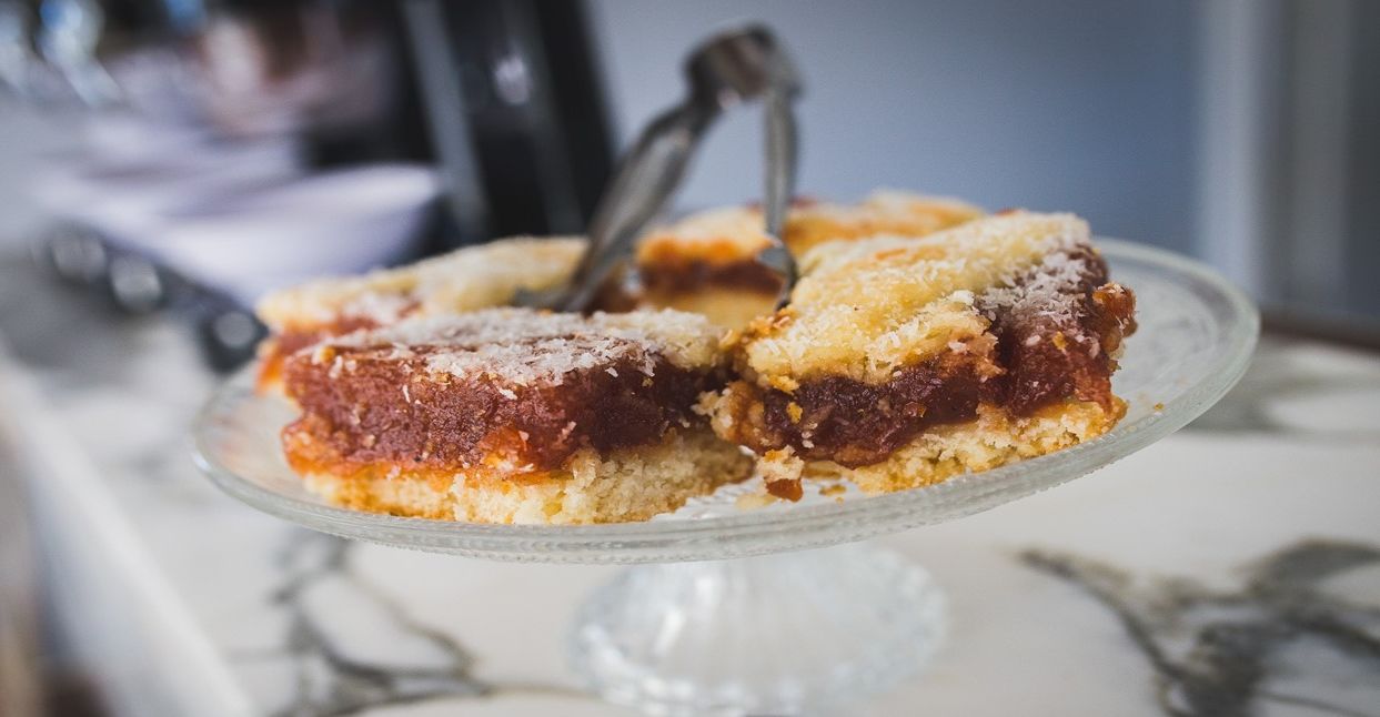 A slice of cake on a clear glass plate with a fork.