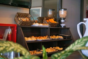A buffet setup with various food items and a coffee machine.