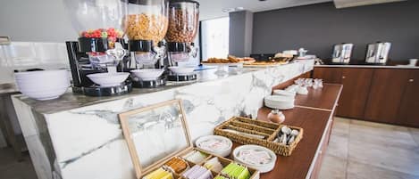 A buffet setup with various food dispensers, bowls, and trays.