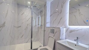 A modern bathroom with a glass-enclosed shower, a toilet, and a vanity with a mirror. - Hotel Express Newcastle Gateshead (Gateshead)