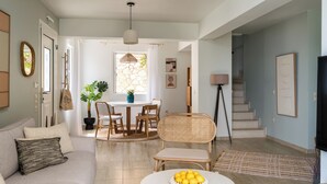 A living room with a sofa, coffee table, and a dining area with chairs and a table. - Villas Muscallas by Konnect, 200m from the Beach. (Paxos)
