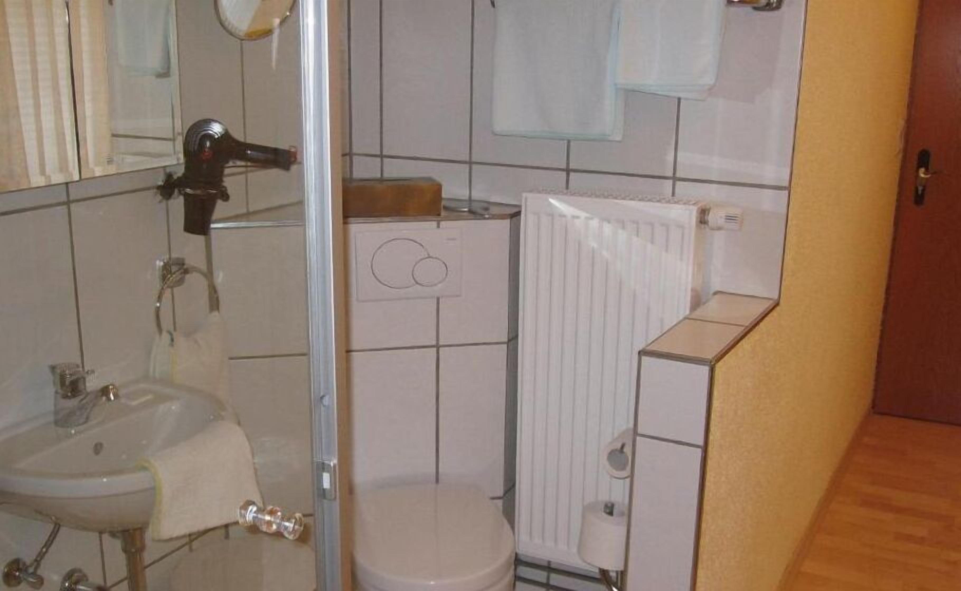 Un baño con inodoro, lavamanos y ducha.