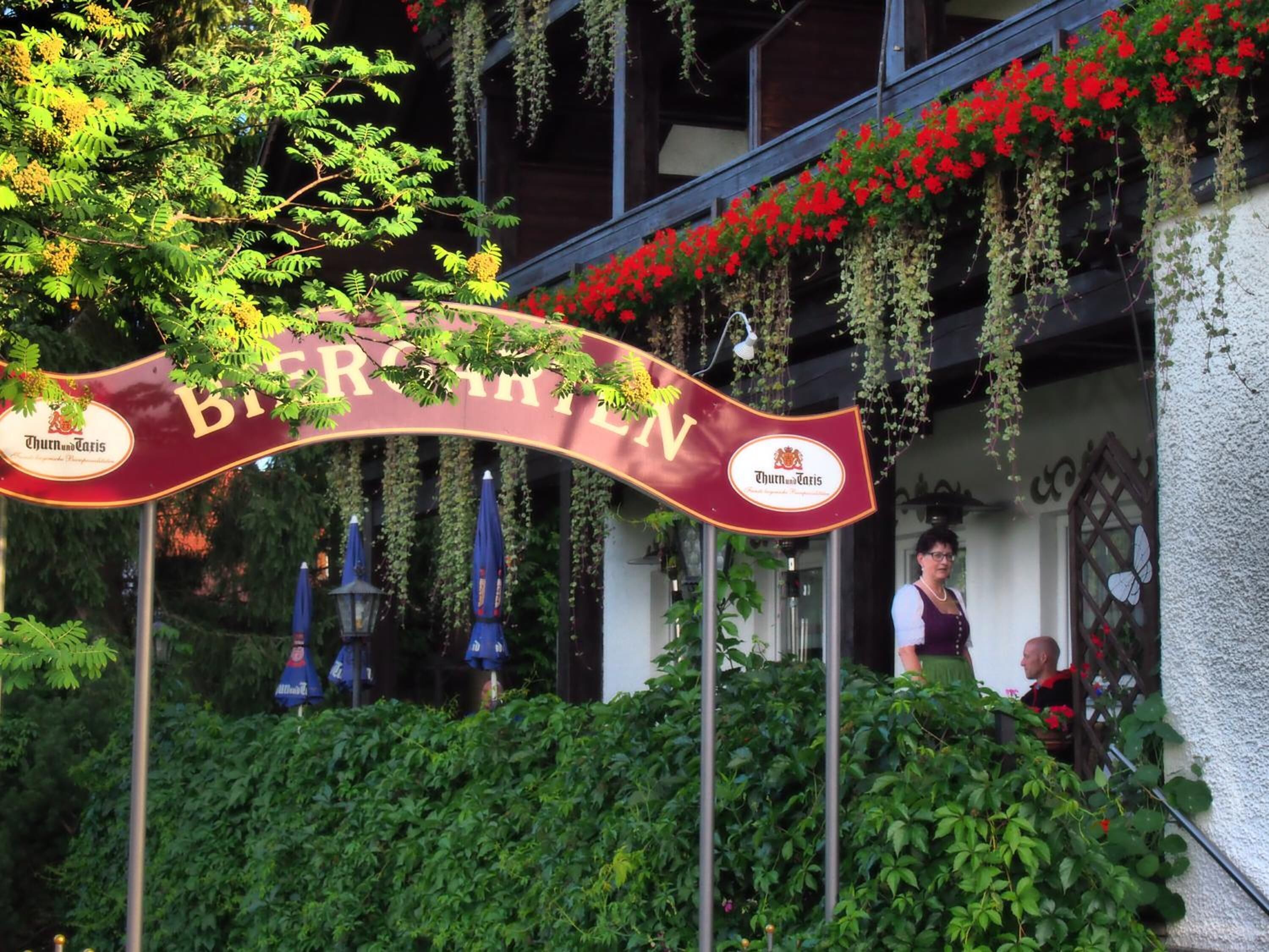 A building entrance with a banner reading "Biergarten" and the Thun und Taris logo.