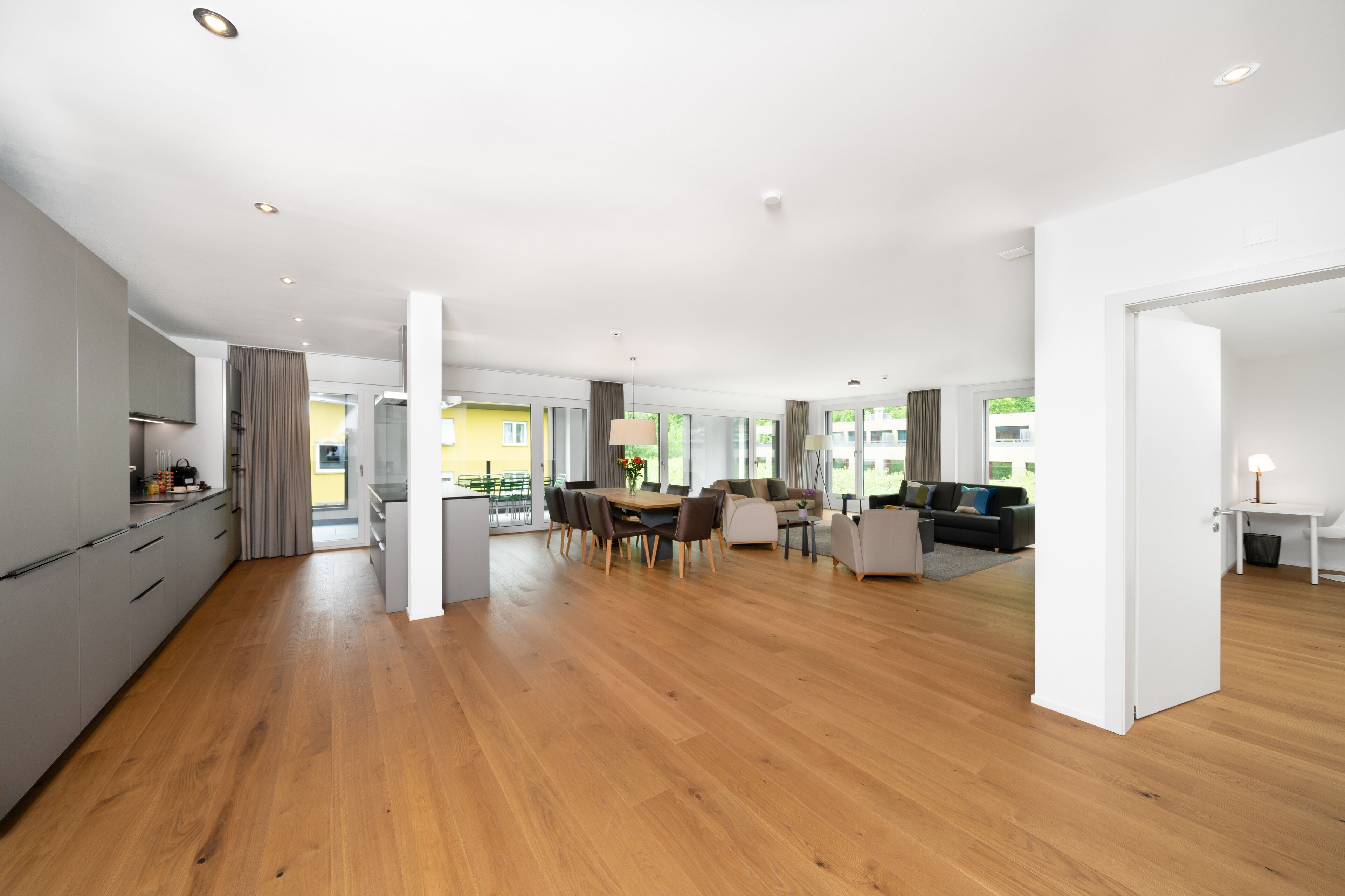 A spacious, modern apartment with a kitchen, dining area, and living room.