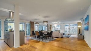 A modern kitchen with a dining area, large windows, and a view of the outside. - Swiss Hotel Apartments-Interlaken (Interlaken)