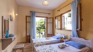 A room with two beds, a small table, a bench, and a window with curtains. - Ipsos Marias Apartments By Konnect (Corfu)