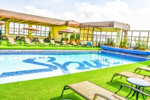 A rooftop pool area with lounge chairs, umbrellas, and a pool with a blue mosaic design. - Verona Hotel & Conference Center (Ruiru)