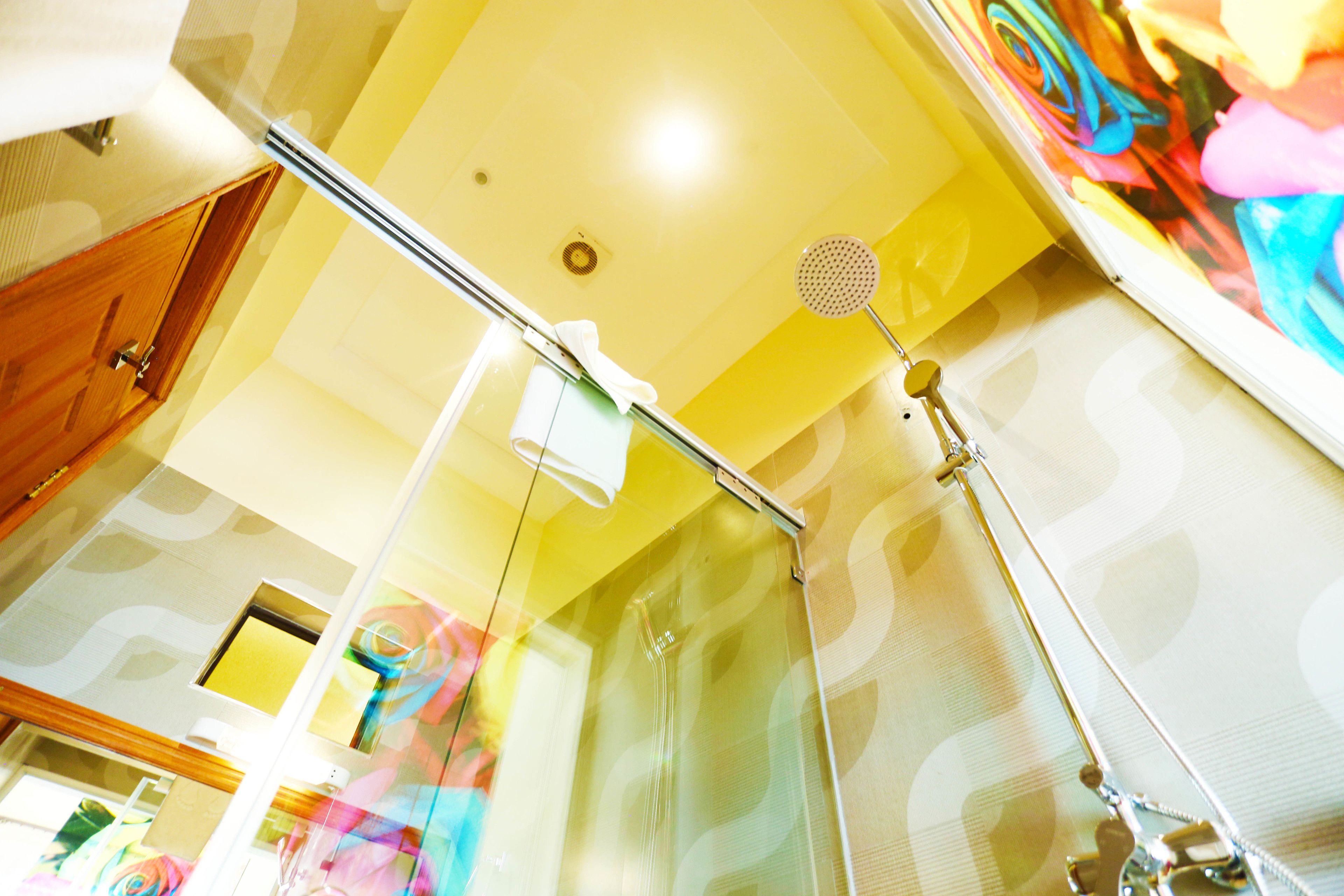Une salle de bain avec une douche à parois de verre, un porte-serviettes et un pommeau de douche.