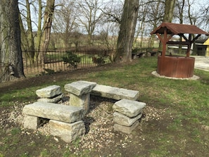 Un banco de piedra con un refugio rústico en un parque.