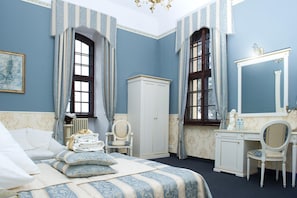 Un dormitorio con cama, cómoda, silla y un espejo grande.
