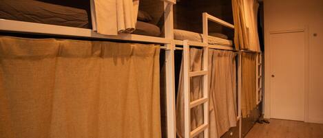 A bunk bed with a ladder, a door, and a wooden floor.