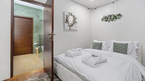 Ein Hotelzimmer mit Bett, Bad und einer Tür zu einem weiteren Raum.