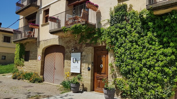 Un edificio con un letrero que dice "Uncastillo Apartamentos" y una puerta de madera.