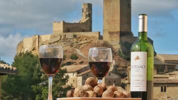 Two wine glasses and a bottle of Borsao Joven 2008 wine, with a plate of walnuts and a view of a historic castle in the background.