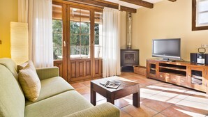 Una sala de estar con un sofá, una mesa de centro, un televisor y una chimenea.