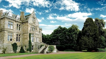 A large, historic stone building with multiple windows and a prominent staircase leading to the entrance.