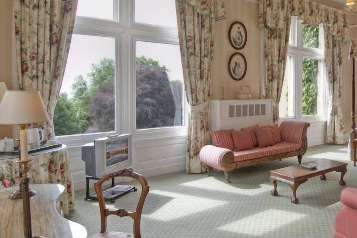 Ein Schlafzimmer mit Bett, Sofa, Couchtisch und Fernseher.