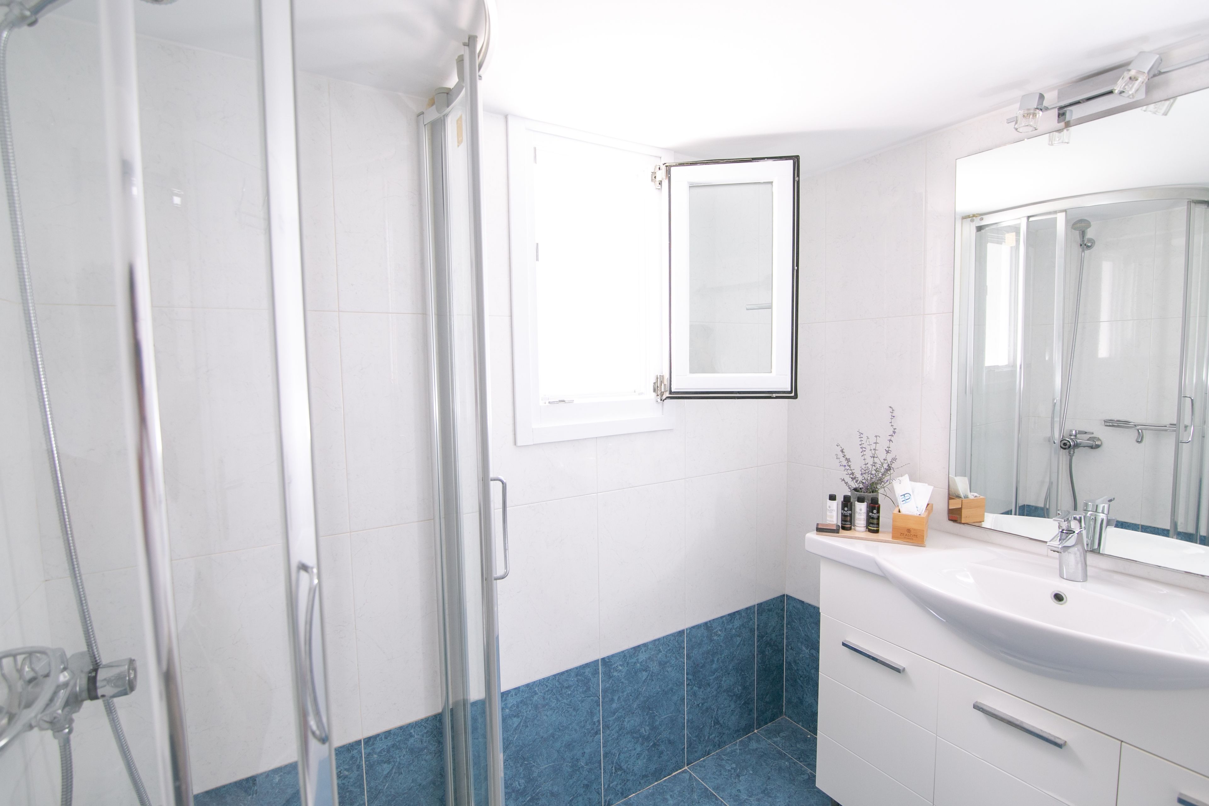 A bathroom with a shower, a sink, and a mirror.