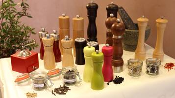 A variety of pepper mills and spice jars on a table.