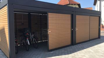 Un edificio moderno con zona de aparcamiento para bicicletas cubierta y un amplio portón de garaje.