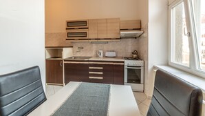 A compact kitchen with wooden cabinets, a stove, and a window providing natural light.