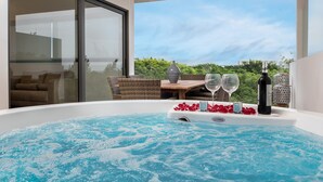 A hot tub with rose petals and wine glasses, a bottle, and a view of greenery. - New and modern 2BR downtown apartment by Happy Address (Playa del Carmen)
