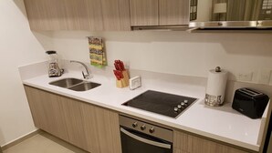 A modern kitchen with a double sink, a built-in stove, a toaster, and a dishwasher. - Cute 1 BR in amazing location by Happy Address (Playa del Carmen)