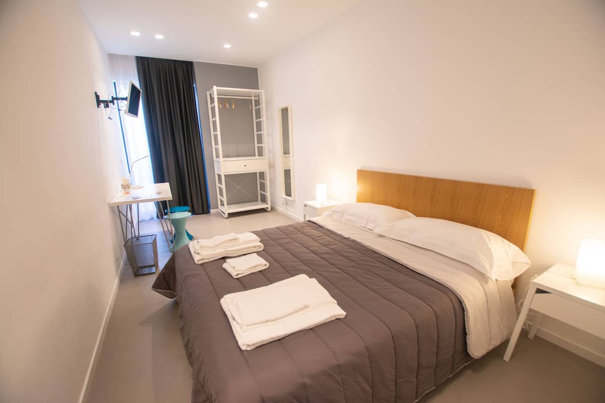Une chambre avec un lit superposé, une table de chevet avec une lampe et un bureau avec une chaise.