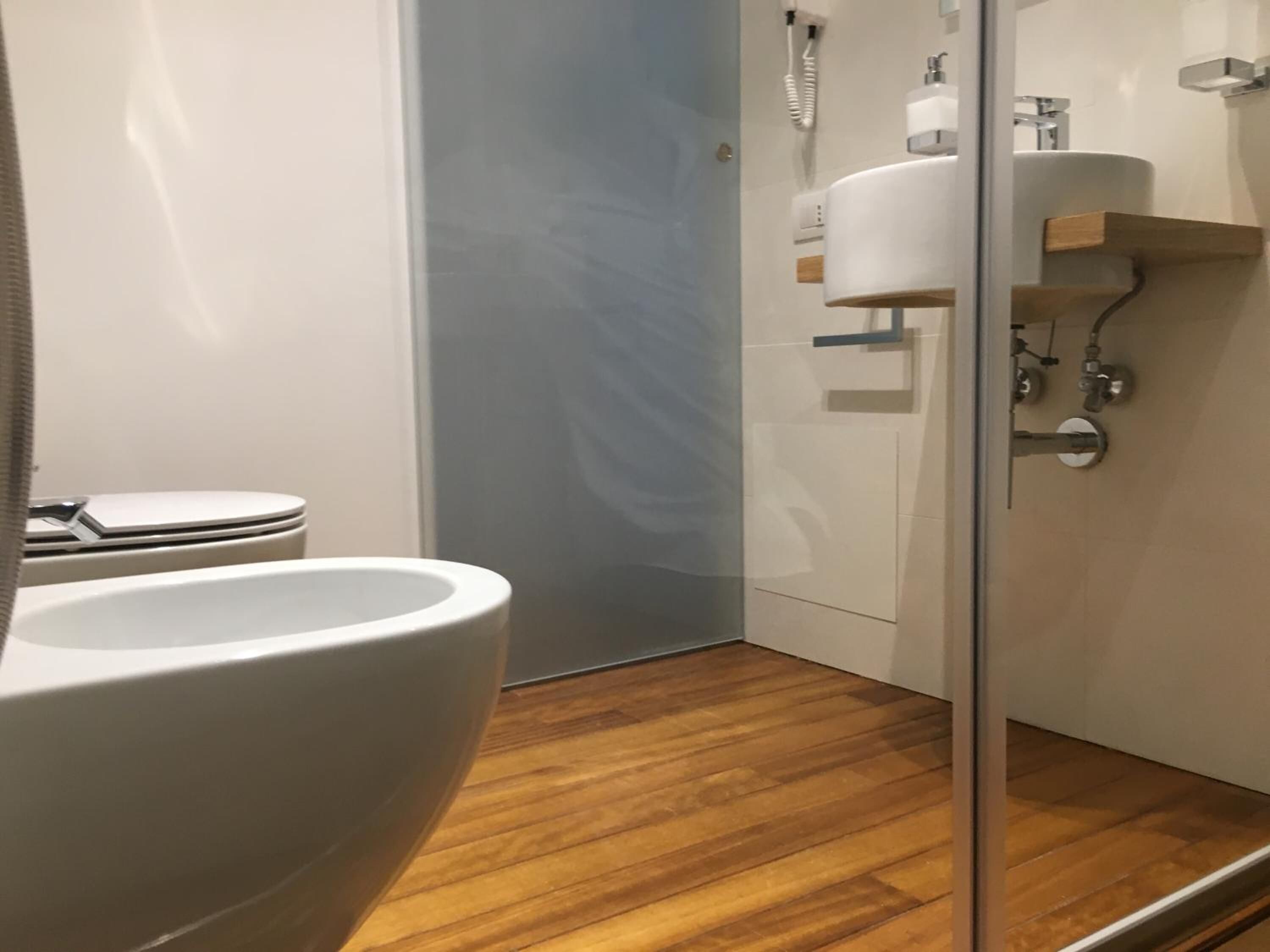 A modern bathroom with a toilet, sink, and shower area.