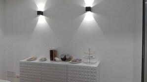 A modern, minimalist room with a white console table displaying various items. - B&B Brezza di Mare (Aci Castello)