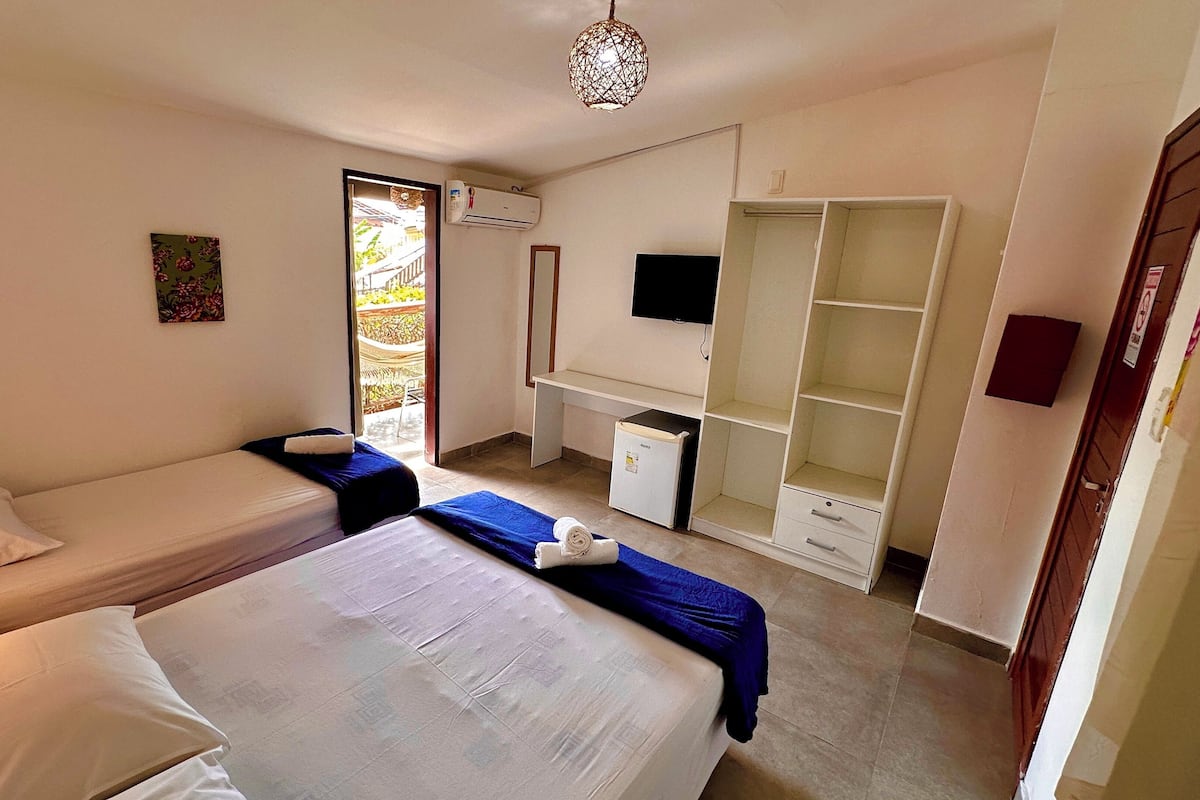 Un dormitorio con dos camas, un escritorio, un armario y un televisor.