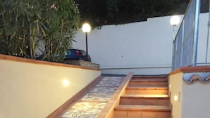 A staircase with a mosaic tile design on the sides and a wooden handrail. - Hotel i Normanni (Praia a Mare)