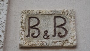 A stone plaque with the inscription "B&B" on a wall.