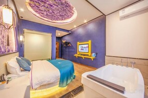A bedroom with a bed, a large window, and a bathroom with a bathtub. - Hongsen Business Hotel (Tengchong)