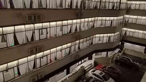A multi-story building with balconies, air conditioning units, and parked cars. - Hongsen Business Hotel (Tengchong)