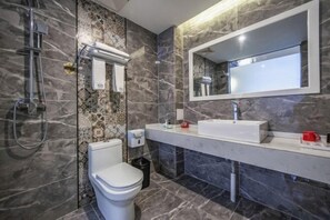 A modern bathroom with a toilet, sink, and shower.