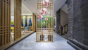 A corridor with a wooden partition, a staircase, and a view of a room with a bed and curtains. - Hongsen Business Hotel (Tengchong)