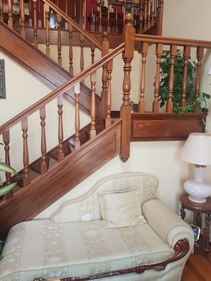 A wooden staircase with a cushioned sofa and a lamp in a room. - Casa Marte (Torrelavega)