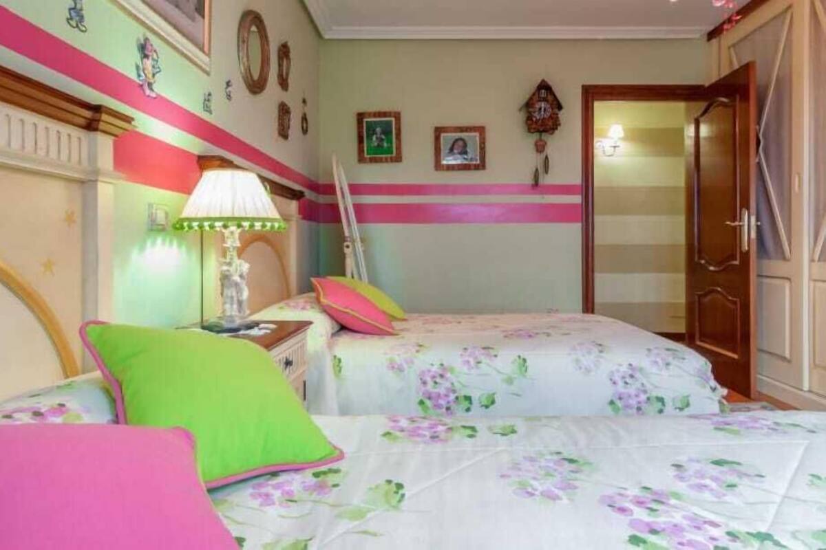 Un dormitorio con dos camas, un armario de madera, un espejo y un reloj de pared.