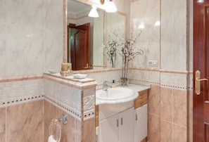 A bathroom with a marble sink, vanity, and a large mirror. - Casa Marte (Torrelavega)