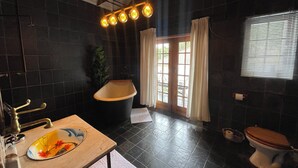 Ein Badezimmer mit Badewanne, Toilette, Waschbecken und einem Vorhangfenster.