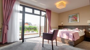 A hotel room with a bed, a chair, a painting, and a view of the outside. - Hotel Figa (Komorniki)