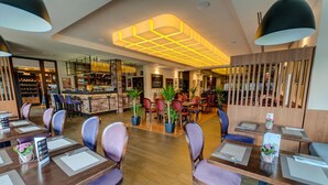 A restaurant with a bar area, wooden tables, and chairs. - Hotel Figa (Komorniki)