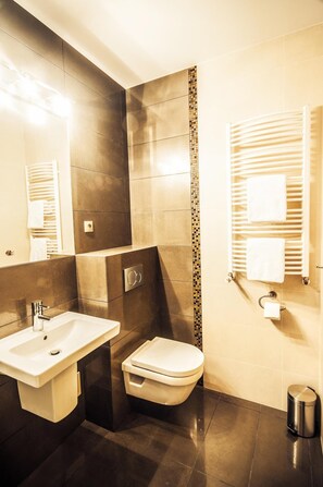 Un baño moderno con lavamanos, inodoro y toalleros.