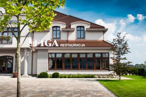 A two-story building with a sign that reads 'FIGA RESTAURACJA'.