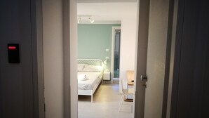 A narrow hallway leading to a bedroom with a bed, bedside table, and a chair. - Simply House in Bari 2 (Bari)