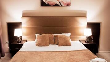 A hotel room with a large bed, two bedside tables, and a painting on the wall.